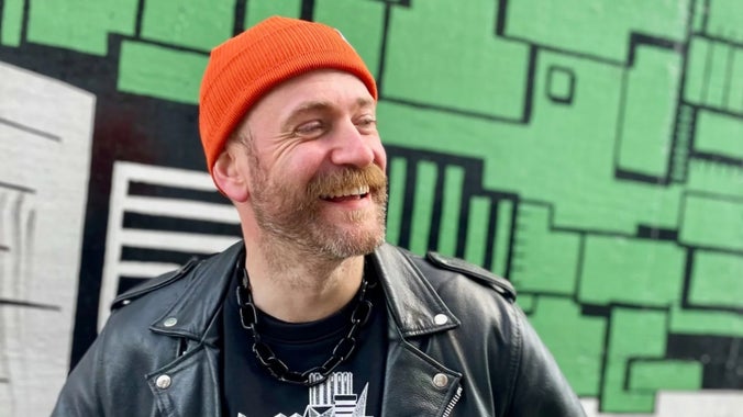 A photography of botanical artist, Edward Luke Thrush, smiling looking looking left.